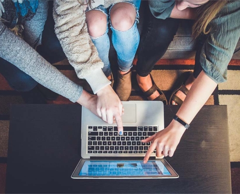 People pointing to a computer